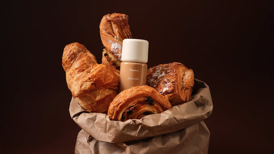 A paper bag of freshly baked pastries photographed in warm, low light
